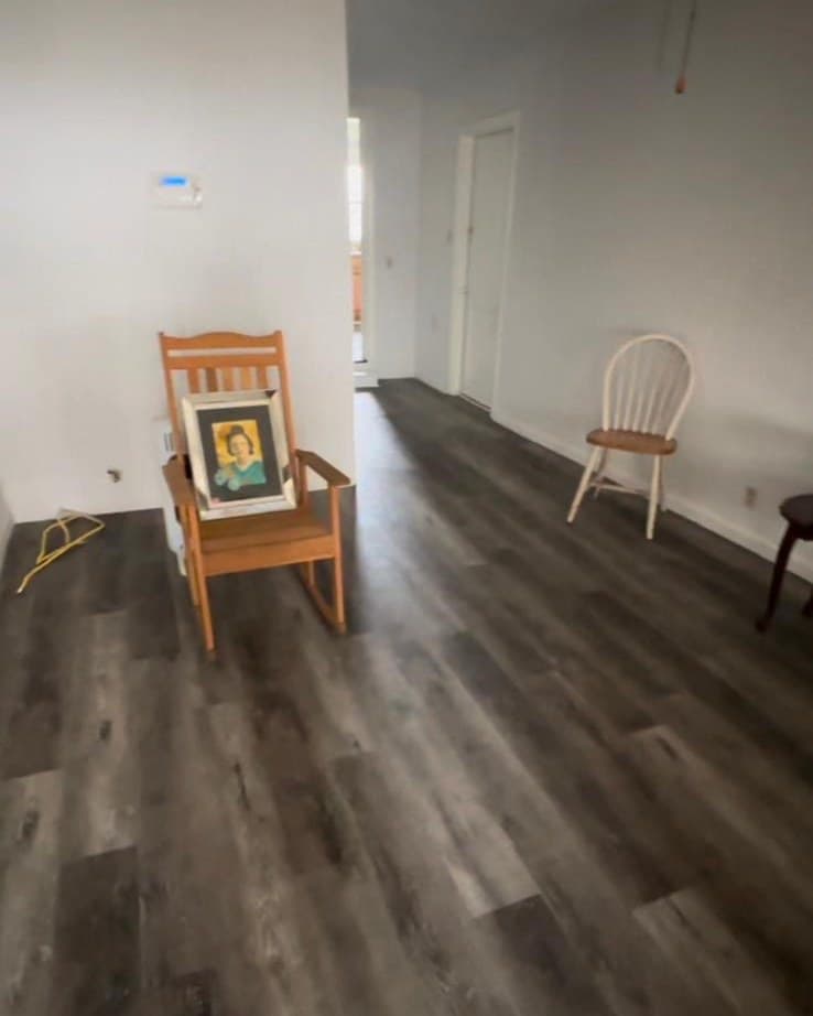 The front room of the Healing House today, empty, with a rocking chair against the wall.